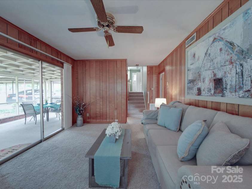 2213 Milton Road, Charlotte, NC 28215.  MLS# CAR4255190, YatesRealty ID 12108. View of den toward steps into kitchen on main level and enclosed porch off the rear level