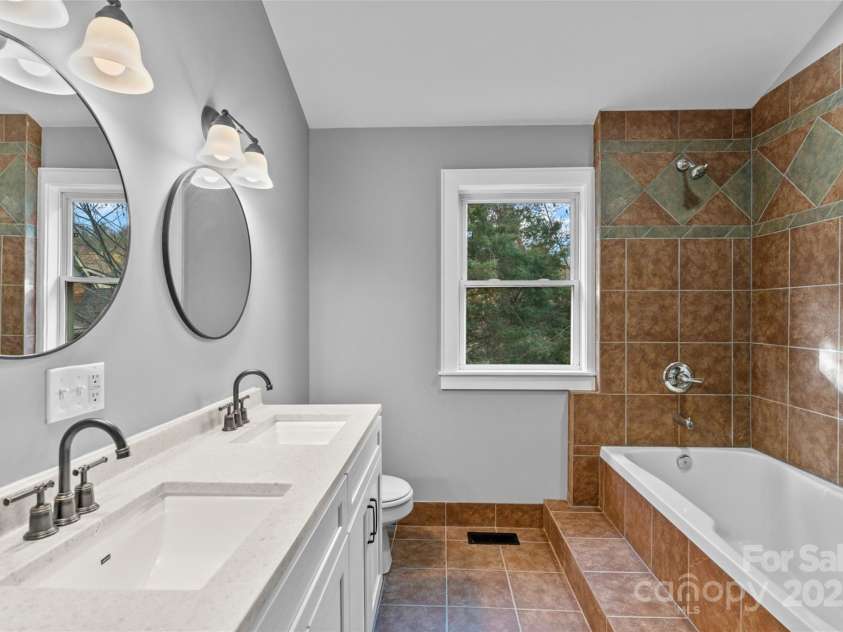 5 Elmore Street, Asheville, NC 28804.  MLS# CAR4252393, YatesRealty ID 12118. Upper bathroom features a bathtub, shower, and double sinks