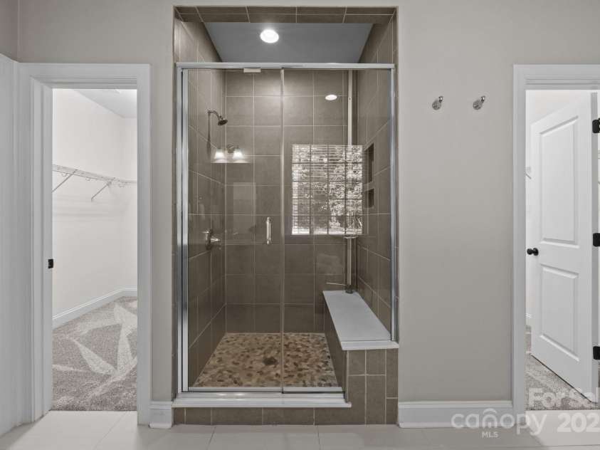 11304 Preservation Lane, Charlotte, NC 28278.  MLS# CAR4249820, YatesRealty ID 12218. The shower ceiling height must be nearly 10 ft!  Huge glass door and pebble floor shower, flanked by walk in closets on both sides