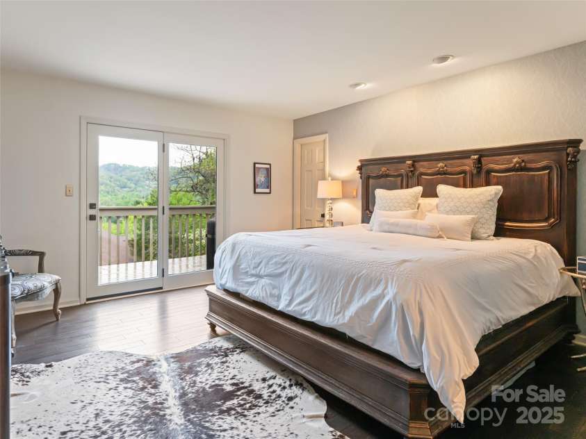 1901 Timber Trail, Asheville, NC 28804.  MLS# CAR4252207, YatesRealty ID 12288. Primary Bedroom Suite on main level with sliding doors to the deck.  Long range mountain views from all areas of bedroom. Complete privacy for sleeping; filled with natural light and lush greenery.