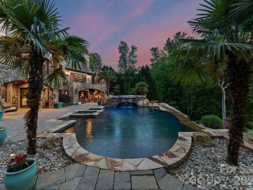 172 Tennessee Circle, Mooresville, NC 28117.  MLS# CAR4252701, YatesRealty ID 1230. Infinity-edge pool with waterfall and integrated spa, surrounded by stone decking.