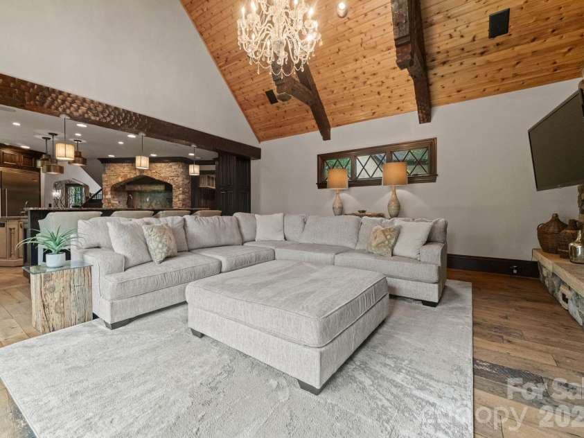 172 Tennessee Circle, Mooresville, NC 28117.  MLS# CAR4252701, YatesRealty ID 1230. Living Room with stone fireplace, dual TVs, and doors to outdoor patio.