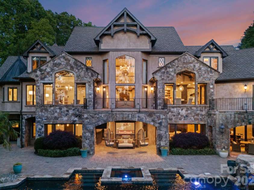 172 Tennessee Circle, Mooresville, NC 28117.  MLS# CAR4252701, YatesRealty ID 1230. Tiered backyard with infinity-edge pool, two covered patios for dining and lounging, and stone pathways leading to the private dock.