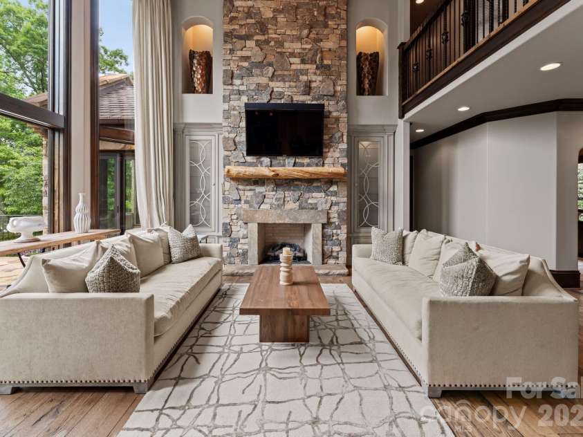 172 Tennessee Circle, Mooresville, NC 28117.  MLS# CAR4252701, YatesRealty ID 1230. Two-story living room with fireplace, chandelier, and custom cabinetry.