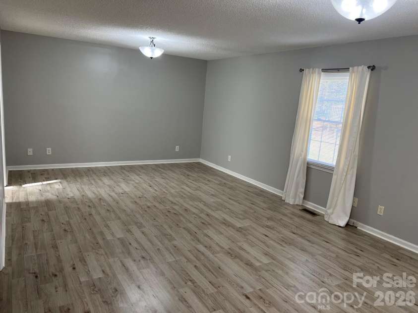 120 Oakley Drive, Gastonia, NC 28052.  MLS# CAR4317380, YatesRealty ID 12318. Expansive primary bedroom with new laminate flooring and lighting 