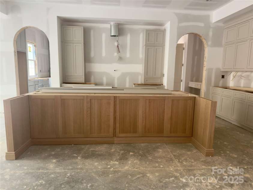 3030 Brookridge Lane, Charlotte, NC 28211.  MLS# CAR4250831, YatesRealty ID 12328. A soft beige tone cabinet creates an inviting, relaxed atmosphere while the beautifully stained island adds rich contrast and character