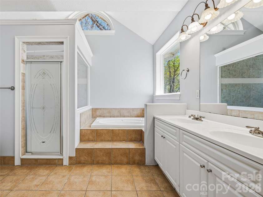 196 Blackbird Lane, Tryon, NC 28782.  MLS# CAR4366022, YatesRealty ID 12349. Primary tiled shower and soaking tub