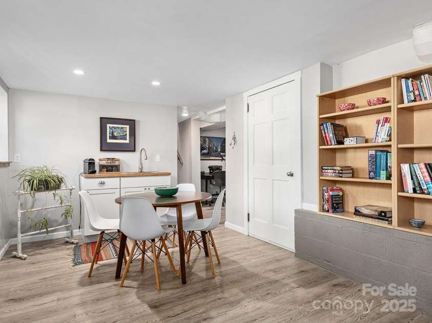 60 Fulton Street, Asheville, NC 28801.  MLS# CAR4196168, YatesRealty ID 12392. Lower level dining and living area features built-in cabinets for storage and newly installed LVT flooring.