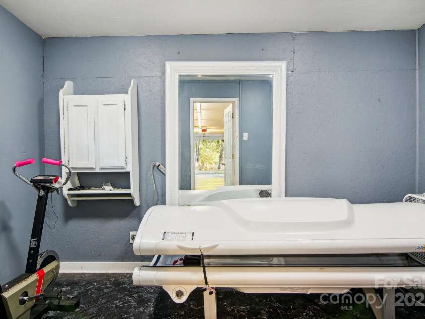 105 Big Bear Drive, Pisgah Forest, NC 28768.  MLS# CAR4192035, YatesRealty ID 12415. Extra room in workshop currently set up as tanning room. Was previously used as hair salon