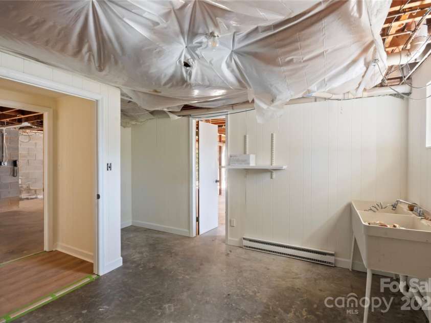 90 Joe Jenkins Road, Fairview, NC 28730.  MLS# CAR4288516, YatesRealty ID 12466. A spacious and well-equipped laundry room, featuring the convenient addition of double wash sinks, providing ample space and functionality for all laundry-related tasks.