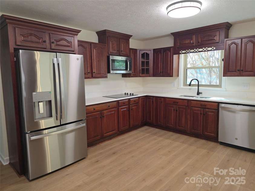 90 Joe Jenkins Road, Fairview, NC 28730.  MLS# CAR4288516, YatesRealty ID 12466. Take a look at the stunning cabinets in this home. We've also installed beautiful new quartz countertops and brand-new, energy-efficient appliances to complete this kitchen remodel.