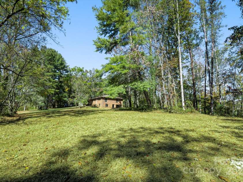 90 Joe Jenkins Road, Fairview, NC 28730.  MLS# CAR4288516, YatesRealty ID 12466. This level property is an outdoor enthusiast's dream, providing an abundance of space that is perfectly suited for cultivating a large, thriving garden, comfortably accommodating a flock of chickens, and creating a safe