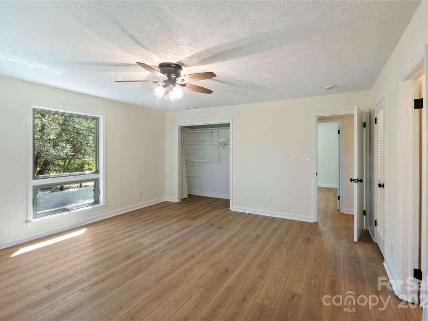 90 Joe Jenkins Road, Fairview, NC 28730.  MLS# CAR4288516, YatesRealty ID 12466. This primary suite is a true oasis, boasting an abundance of natural light that streams in throughout the day. The space has been thoughtfully designed with a modern, updated luxury bathroom, offering a tranquil and rej