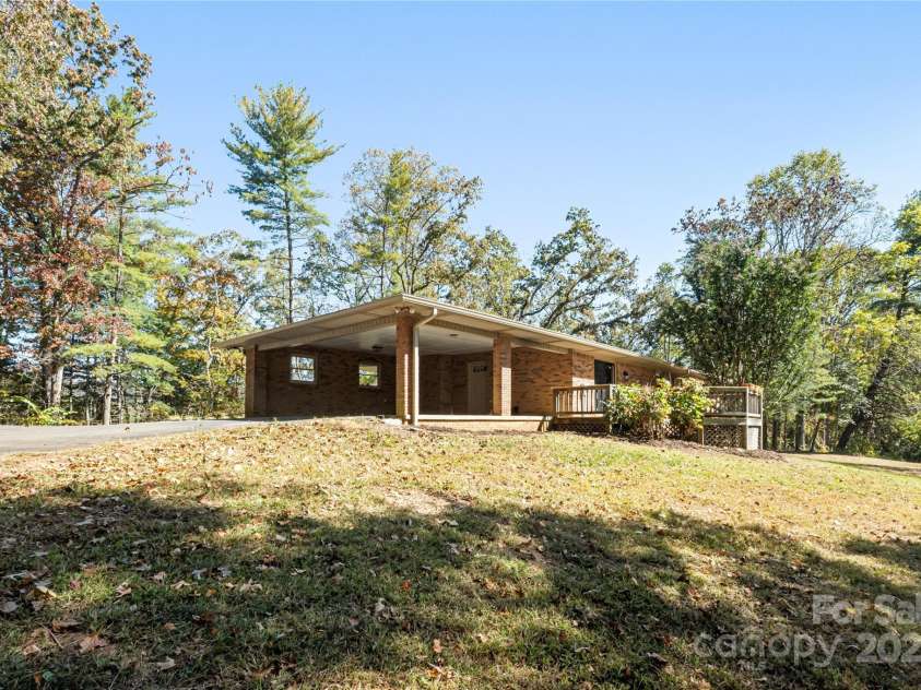 90 Joe Jenkins Road, Fairview, NC 28730.  MLS# CAR4288516, YatesRealty ID 12466. This property features a large carport, providing convenient covered parking, which is especially useful when unloading groceries, ensuring they stay dry and protected from the elements during transport from the car to 