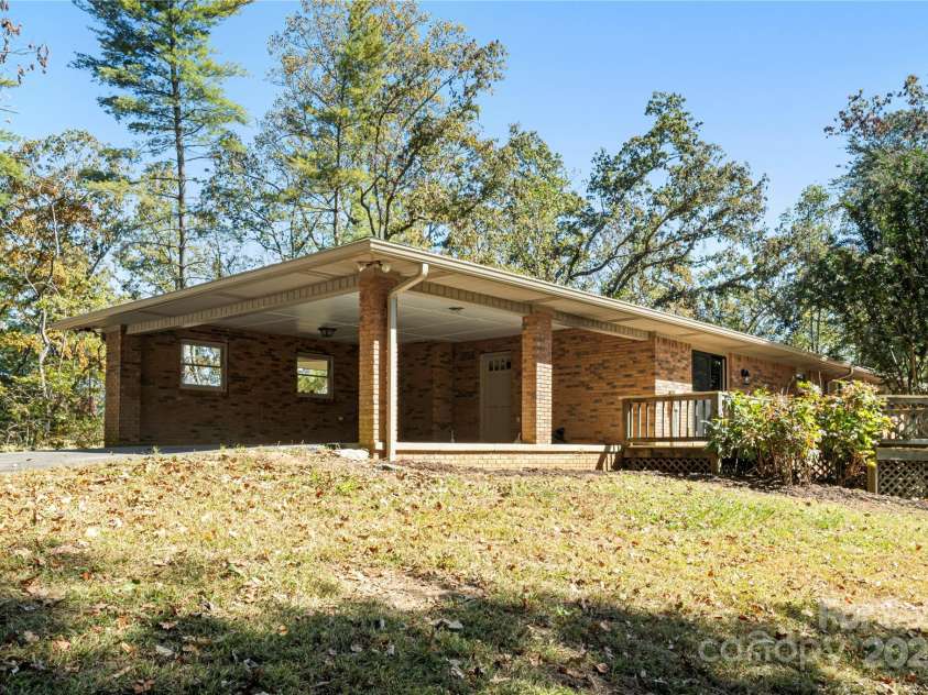 90 Joe Jenkins Road, Fairview, NC 28730.  MLS# CAR4288516, YatesRealty ID 12466. This property features a large carport, providing convenient covered parking, which is especially useful when unloading groceries, ensuring they stay dry and protected from the elements during transport from the car to 