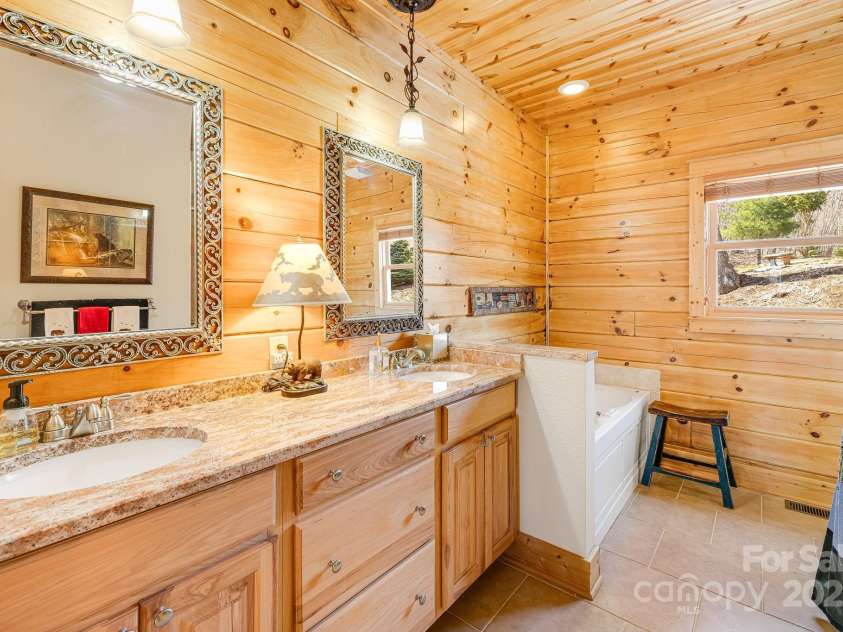 100 Flame Azalea Lane, Mars Hill, NC 28754.  MLS# CAR4248115, YatesRealty ID 12470. Elegant bath with dual vanities and a beautifully tiled walk-in shower.