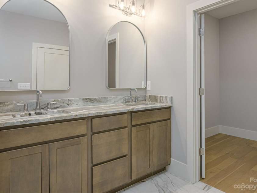 33 Course Drive, Etowah, NC 28729.  MLS# CAR4069124, YatesRealty ID 1248. Double sink vanity in primary leads to primary walk-in closet.