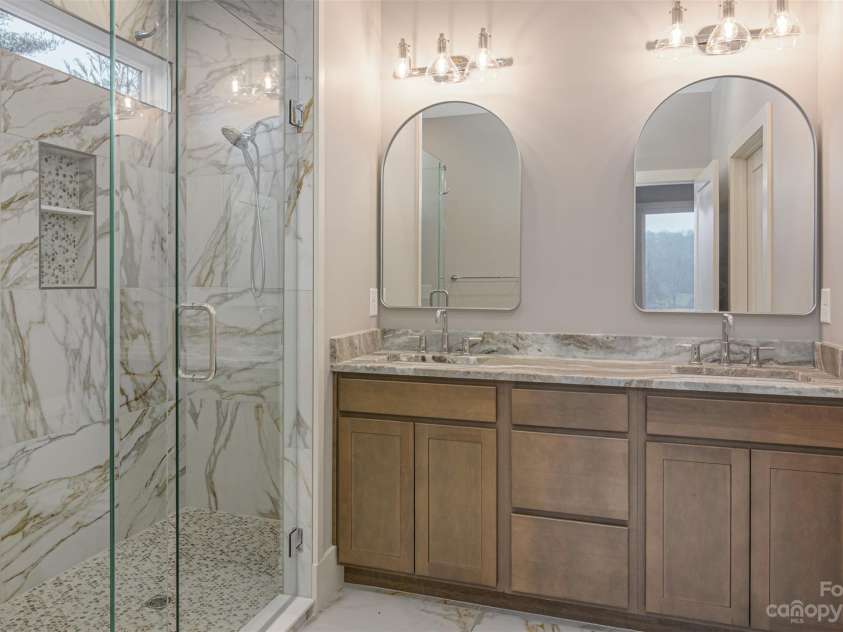 33 Course Drive, Etowah, NC 28729.  MLS# CAR4069124, YatesRealty ID 1248. Double vanity in primary  bathroom - granite counter tops - tiled glass shower, also a transit window in primary bathroom