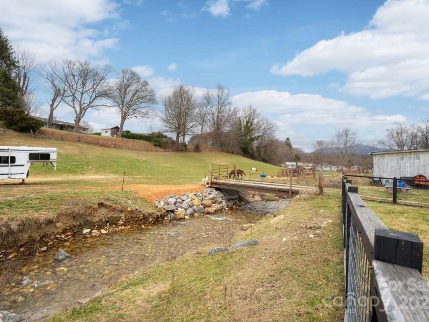 1134 Plott Creek Road, Waynesville, NC 28786.  MLS# CAR4221979, YatesRealty ID 12485. Gentle walk down slope to creek.