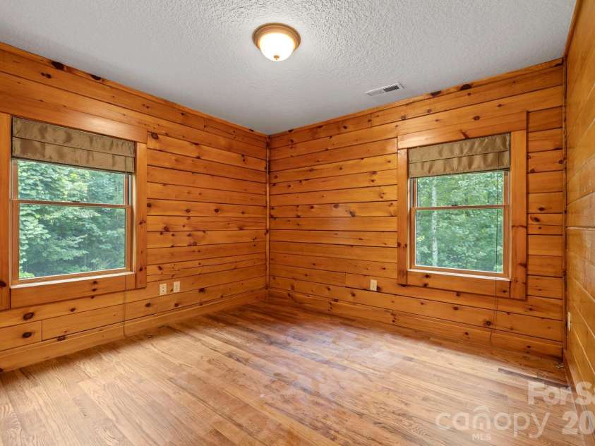 266 Rhododendron Drive, Saluda, NC 28773.  MLS# CAR4367080, YatesRealty ID 12496. Bright corner bedroom with multiple windows, offering natural light and tranquil views.