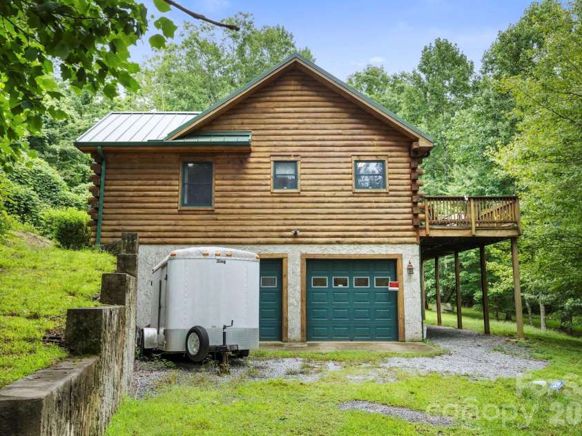 266 Rhododendron Drive, Saluda, NC 28773.  MLS# CAR4367080, YatesRealty ID 12496. Lower-level, two car garage with additional storage space and a spacious driveway, providing convenience and functionality.