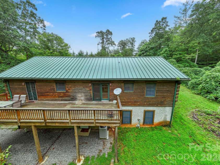 266 Rhododendron Drive, Saluda, NC 28773.  MLS# CAR4367080, YatesRealty ID 12496. Rear exterior view highlighting the elevated deck and peaceful backyard setting.
