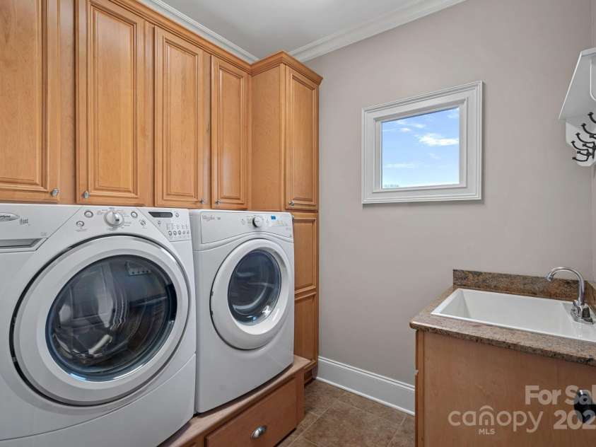 15015 NC Hwy 73 Highway, Huntersville, NC 28078.  MLS# CAR4226627, YatesRealty ID 12520. Laundry room accessed off garage and adjacent to the kitchen with custom cabinetry and built-in washer/dryer pedestals...large farm sink.