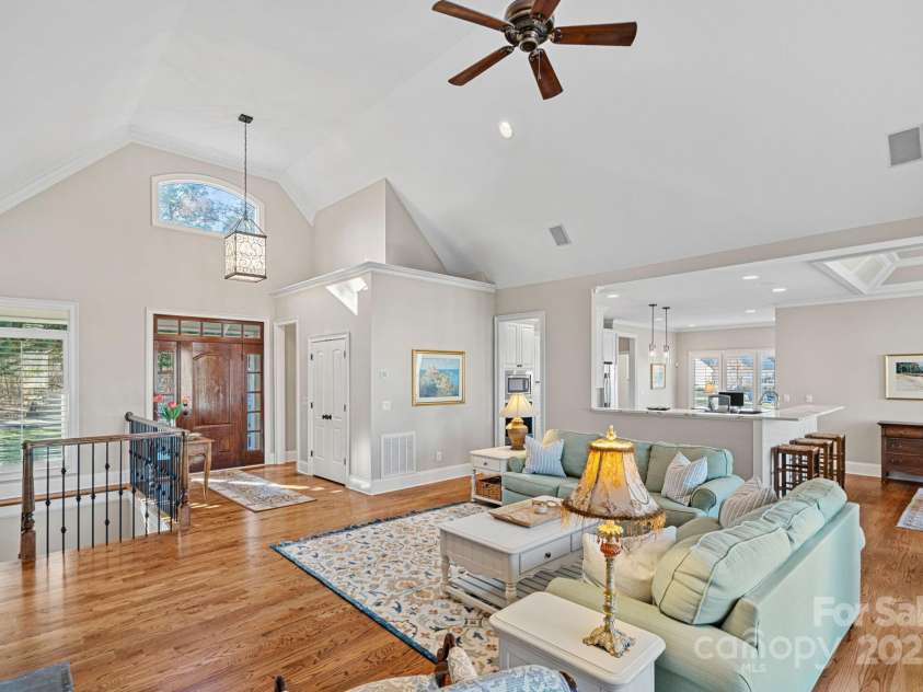 15015 NC Hwy 73 Highway, Huntersville, NC 28078.  MLS# CAR4226627, YatesRealty ID 12520. Stunning living room with vaulted ceiling, full-height stone fireplace, built-ins, and lake views!