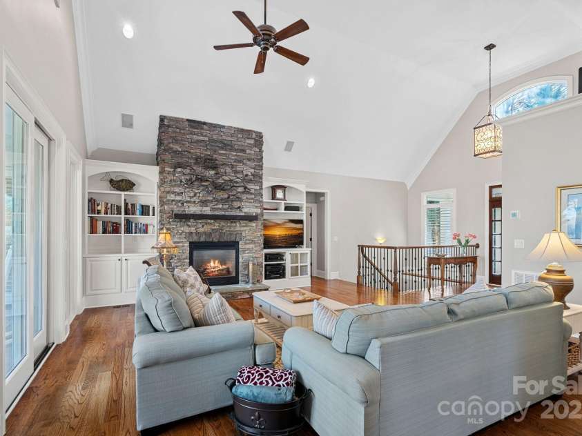 15015 NC Hwy 73 Highway, Huntersville, NC 28078.  MLS# CAR4226627, YatesRealty ID 12520. Stunning living room with vaulted ceiling, full-height stone fireplace, built-ins, and lake views!