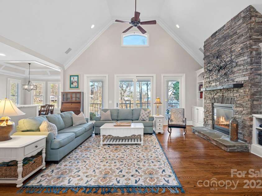 15015 NC Hwy 73 Highway, Huntersville, NC 28078.  MLS# CAR4226627, YatesRealty ID 12520. Stunning living room with vaulted ceiling, full-height stone fireplace, built-ins, and lake views!
