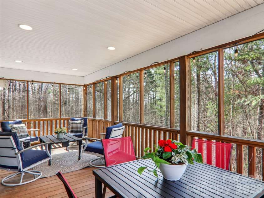 74 Woodson Drive, Mars Hill, NC 28754.  MLS# CAR4355311, YatesRealty ID 12666. Covered screened deck overlooking wooded backyard