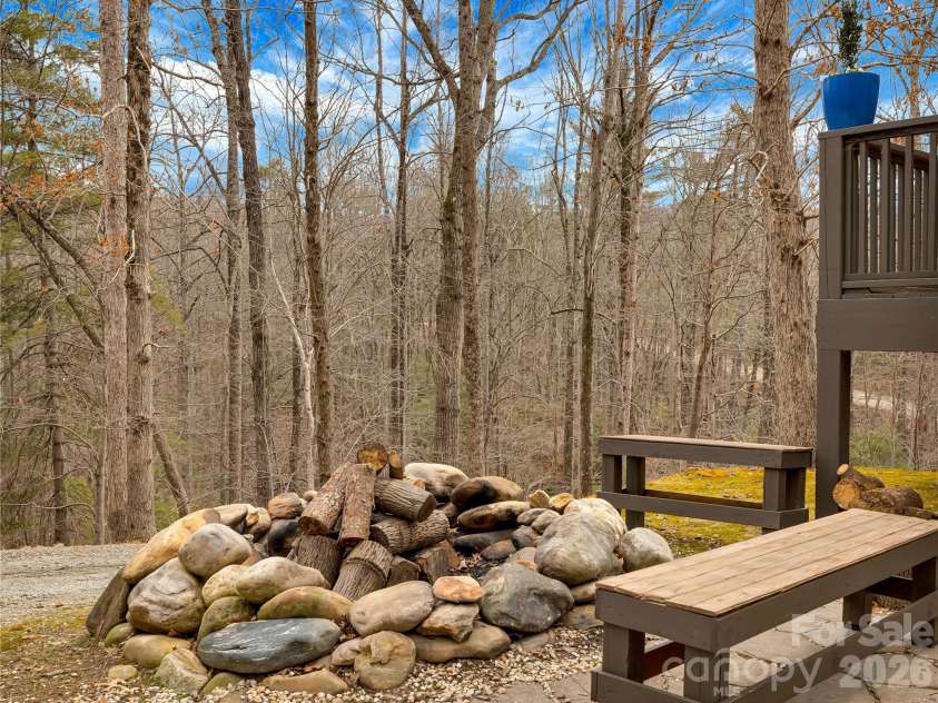 184 Deep Woods Lane, Saluda, NC 28773.  MLS# CAR4333233, YatesRealty ID 12686. River-rock fire circle