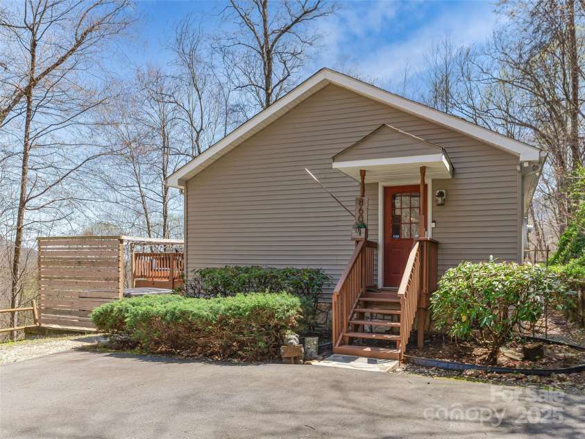 860 Creekside Drive, Maggie Valley, NC 28751.  MLS# CAR4245544, YatesRealty ID 12700. Featuring the entrance to the kitchen, hot tub area with mountain views in the distance.