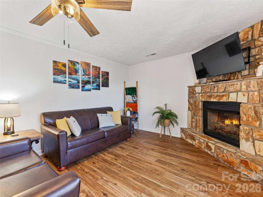 860 Creekside Drive, Maggie Valley, NC 28751.  MLS# CAR4329432, YatesRealty ID 12700. Living room with corner fireplace