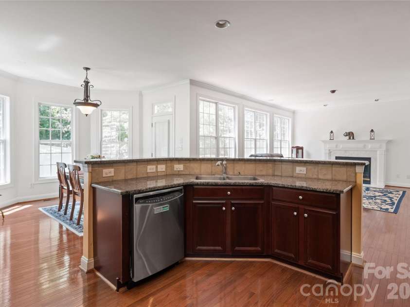 8914 Landsdowne Avenue, Harrisburg, NC 28075.  MLS# CAR4259422, YatesRealty ID 1276. Kitchen area overlooking the breakfast are and a view of the expansive windows in the family lroom designed to maximize natural light providing stunning views of the back yard.