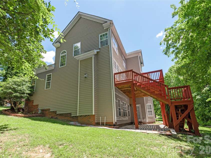 8914 Landsdowne Avenue, Harrisburg, NC 28075.  MLS# CAR4259422, YatesRealty ID 1276. Side view of home showing the stairs to the deck.