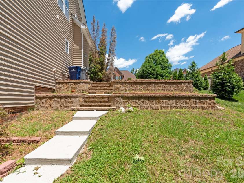 8914 Landsdowne Avenue, Harrisburg, NC 28075.  MLS# CAR4259422, YatesRealty ID 1276. Side view of stairs going to the back of house.