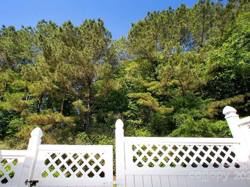 4938 Sunset Ridge Court, Charlotte, NC 28269.  MLS# CAR4256008, YatesRealty ID 12774. Step outside to the serene back patio, surrounded by a wooded area that ensures privacy and tranquility.
