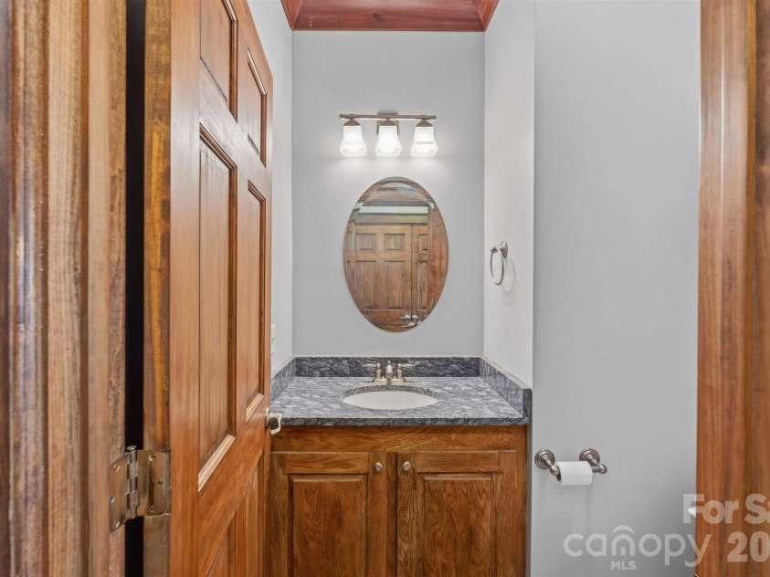 22 Pear Tree Lane, Leicester, NC 28748.  MLS# CAR4371027, YatesRealty ID 12806. Half bath in the hallway of the main level also has granite counters and custom white oak cabinetry.