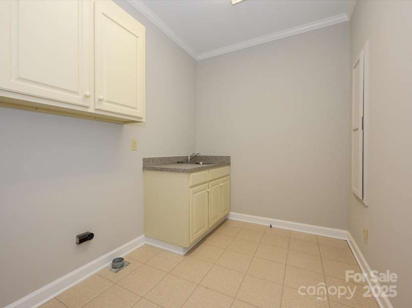 1448-1 New Prospect Church Road, Shelby, NC 28150.  MLS# CAR4214412, YatesRealty ID 12811. Laundry Room is large. It has overhead cabinets for storage, a sink & a fold-down ironing board.