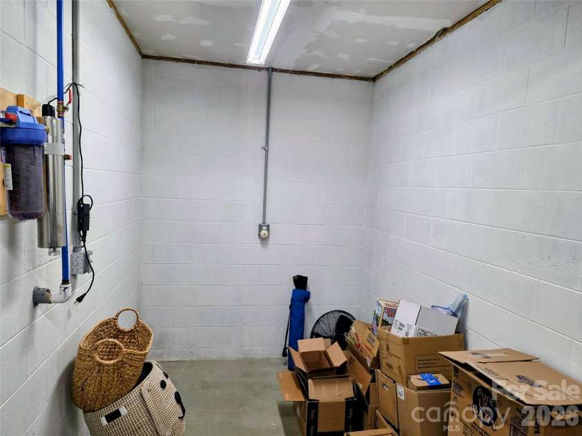 254 Ray Mine Road, Burnsville, NC 28714.  MLS# CAR4351718, YatesRealty ID 12813. Water line entering lower level storage space with UV filter and regular cartridge filter