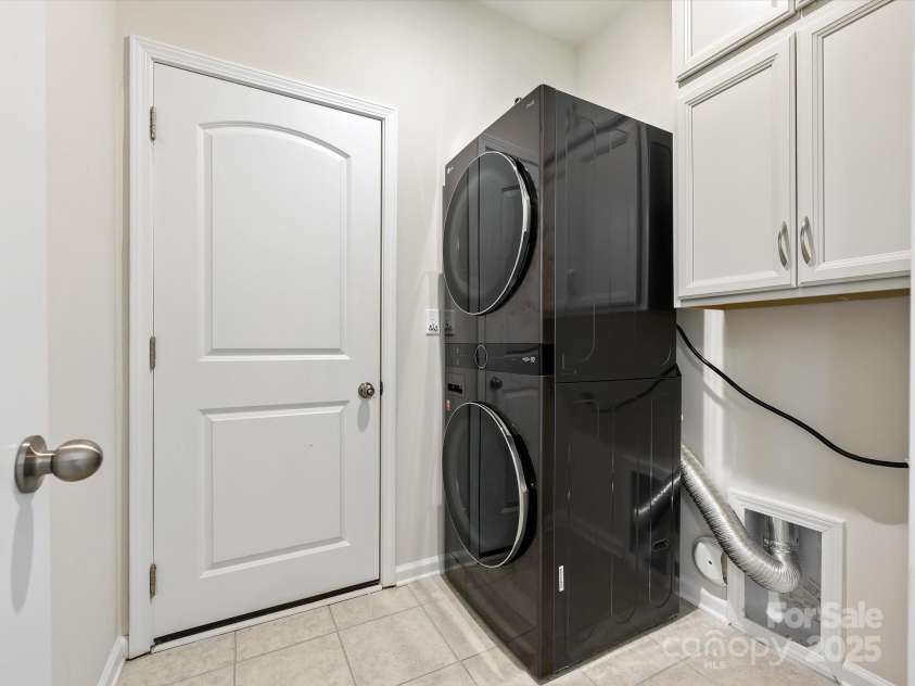 3813 Amalia Place, Indian Land, SC 29707.  MLS# CAR4246224, YatesRealty ID 12822. Main Level Laundry Room with access from the garage includes a stacked Washer & Dryer (to convey), wall cabinets and tile floors.