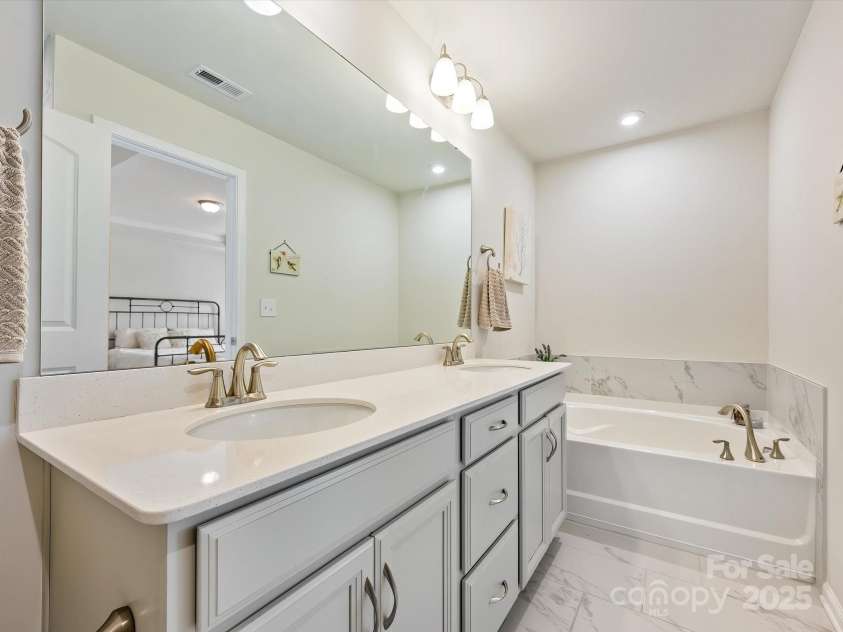 3813 Amalia Place, Indian Land, SC 29707.  MLS# CAR4246224, YatesRealty ID 12822. Second Story Primary Bathroom includes dual sinks & vanities, a garden tub, Walk in Shower with luxury tile flooring & shower walls.
