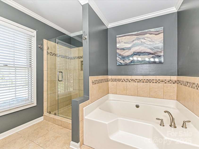 11 Tanglewood Road, Lake Wylie, SC 29710.  MLS# CAR4237959, YatesRealty ID 12829. The en suite primary bath features a tiled shower and separate soaking tub.
