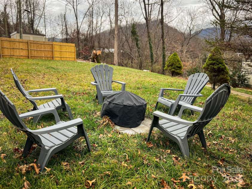 805 Reems Creek Road, Weaverville, NC 28787.  MLS# CAR4206802, YatesRealty ID 12835. Fun fire pit area in large front yard with brand new fence.
