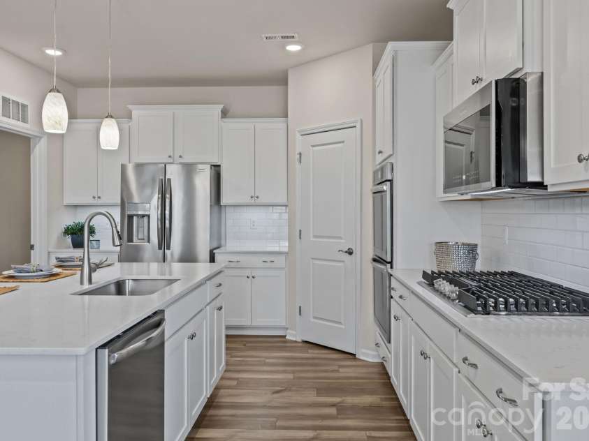 4840 Maiden Creek Way, Maiden, NC 28650.  MLS# CAR4367470, YatesRealty ID 12836. Lots of room to work and play! Thoughtfully designed with large stainless sink and pulldown sprayer near the island diswasher.  This is the GOURMET UPGRADED PACKAGE.  Notice the custom built-in gas range!