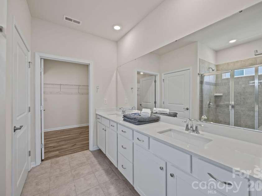 4840 Maiden Creek Way, Maiden, NC 28650.  MLS# CAR4367470, YatesRealty ID 12836. PRIMARY ensuite full bath with long quartz countertop featuring popular squared sinks and loads of room. Separate doored toilet facility, tiled floors and ample sized shower.  Door leads to expansive closet! Enjoy!