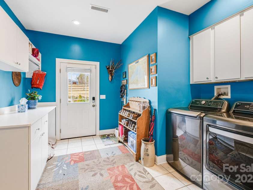169 Stoneybrook Way, Tryon, NC 28782.  MLS# CAR4217213, YatesRealty ID 1286. Laundry room includes washer and dryer, deep sink, and storage with counterspace.  Exterior door with a view.