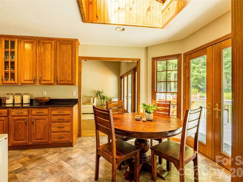 226 Wildcat Mountain Trail, Sylva, NC 28779.  MLS# CAR4284312, YatesRealty ID 12873. Dining table off kitchen with skylight overhead
