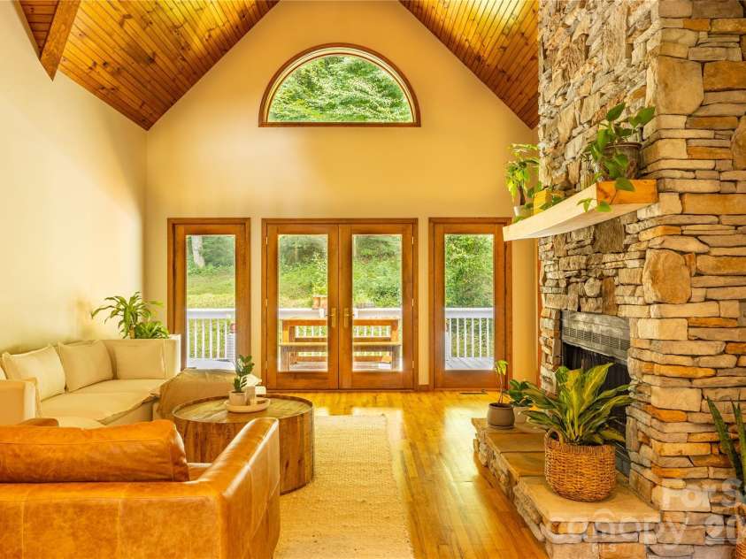 226 Wildcat Mountain Trail, Sylva, NC 28779.  MLS# CAR4284312, YatesRealty ID 12873. Great room with cathedral ceiling and stone fireplace